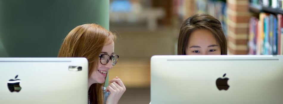 two-students-behind-laptop-screens